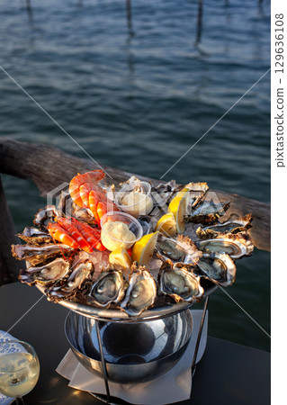 Tasting fresh oysters and shrimps 129636108