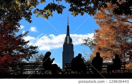 Autumnal Silhouette of People on Bench with Empire State Buildin Autumnal Silhouette of People on Bench with Empire State Buildin 129636443