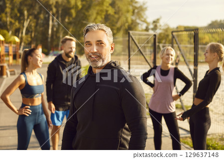 Portrait of smiling mature sporty man looking at camera after fit exercises in nature in the park. Portrait of smiling mature sporty man looking at camera after fit exercises in nature in the park. 129637148