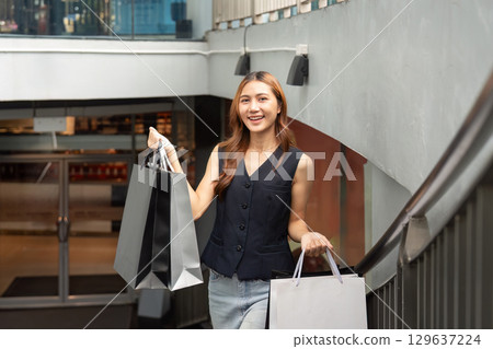 Black Friday shopping excitement with stylish woman carrying bags Black Friday shopping excitement with stylish woman carrying bags 129637224