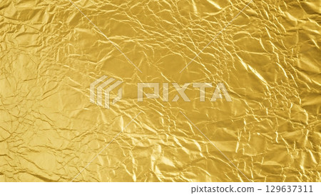 Crumpled gold foil with rich metallic texture and expressive reflective surface design Crumpled gold foil with rich metallic texture and expressive reflective surface design 129637311