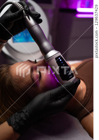 Professional endosphere therapy facial massage for skin tightening, rejuvenation, and anti aging in a modern spa clinic. 129637429