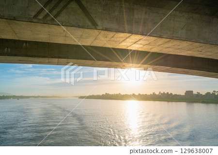 Sunset on the Nile River Near Luxor Under a Bridge. 129638007