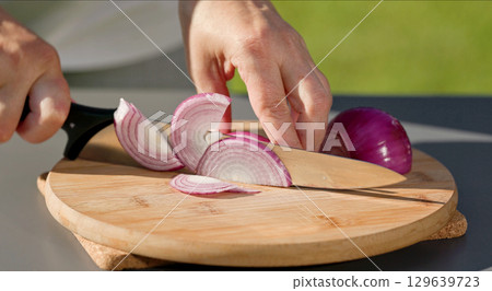 chef cuts fresh red onion 129639723