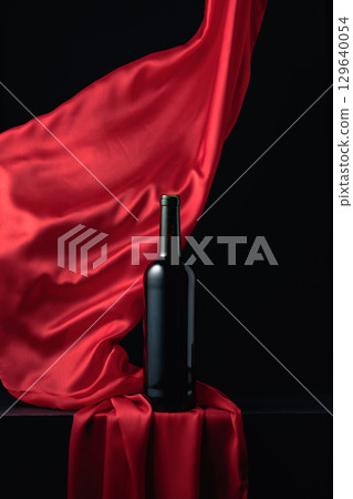 Bottle of red wine and flutters of red cloth. Bottle of red wine and flutters of red cloth. 129640054