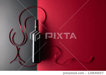 Bottle of red wine with red satin ribbons. 129640057