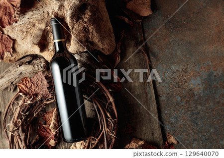 Bottle of red wine on a vintage rustic background. Bottle of red wine on a vintage rustic background. 129640070