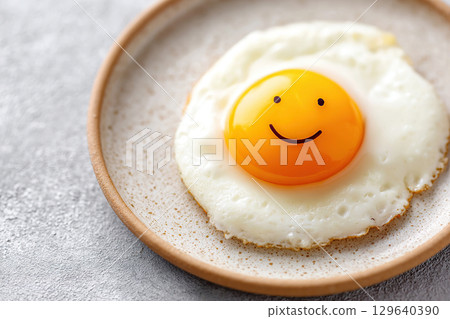 Smiling yolk in fried egg served on a plate for breakfast 129640390