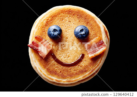 Creative breakfast face made from pancakes with blueberries and bacon 129640412