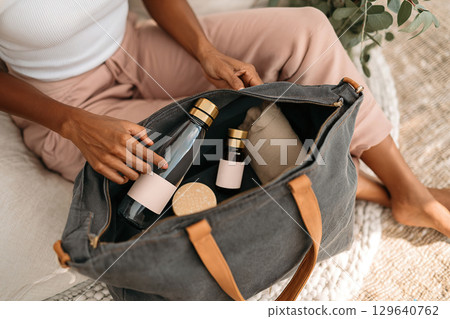 Unpacking a reusable tote bag with eco-friendly items in a cozy living space 129640762