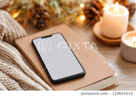 Detox moment with turned off phone beside cozy blanket and candles 129641018