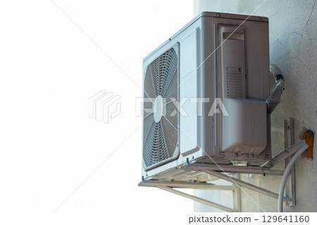 Air conditioner outdoor unit compressor on the wall of a high story building. Conditioning air inside the building Air conditioner outdoor unit compressor on the wall of a high story building. Conditioning air inside the building 129641160