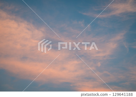 Light clouds in sky after sunset. Calm evening with clouds illuminated by last rays of sun 129641188