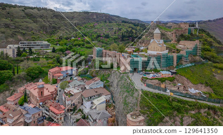Aerial view on old town Tbilisi on Kura river in Tbilisi  and Metekhi bridge and pedestrian bridge in distance 129641350