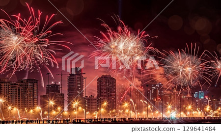 At night, a dazzling fireworks display lights up the city skyline 129641484