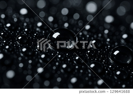 Detailed close-up of dark water droplets with high gloss effect on black background 129641688