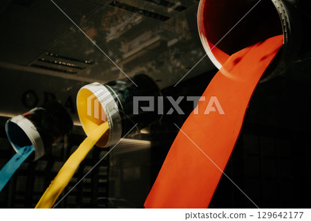 Buckets tilted and pouring different colors of paint creating a colorful scene. A captivating shot of vibrant paint pouring from upside-down buckets. 129642177
