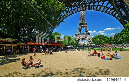 Eiffel Tower Framed by Ironwork and Summer Beach Scene in Paris 129644644