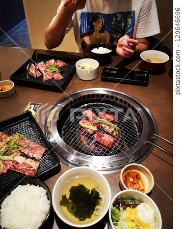 A Chinese woman eating yakiniku lunch at a newly opened yakiniku restaurant A Chinese woman eating yakiniku lunch at a newly opened yakiniku restaurant 129646696