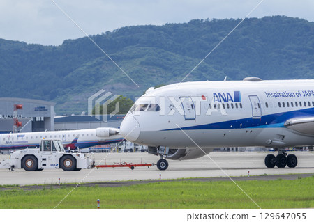 Sendai Airport in summer, towing tractor and airplane, Natori City, Miyagi Prefecture 129647055