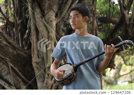 Okinawan boy playing the sanshin Okinawan boy playing the sanshin 129647106