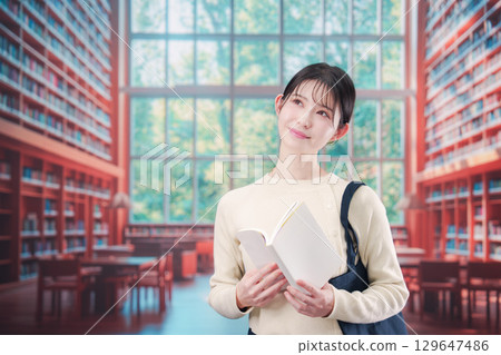 在明亮的圖書館裡看書的年輕女子 在明亮的圖書館裡看書的年輕女子 129647486
