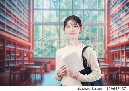 在明亮的圖書館裡看書的年輕女子 在明亮的圖書館裡看書的年輕女子 129647487
