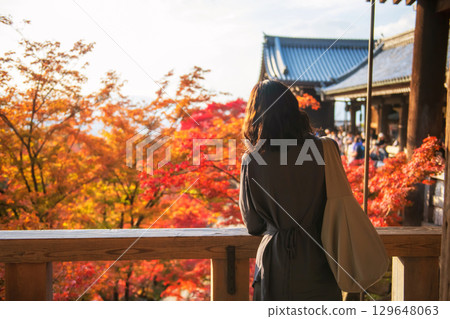 Japanese woman view autumn leaf in Kiyomizu dera temple at sunset, Kyoto 129648063