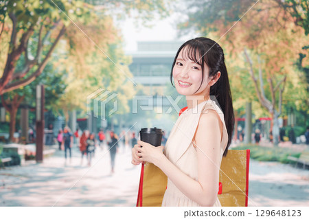 Young student walking outside drinking coffee Young student walking outside drinking coffee 129648123