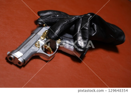 Revolver with Black hand gloves Revolver with Black hand gloves 129648354
