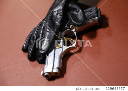 Revolver with Black hand gloves  Revolver with Black hand gloves  129648357