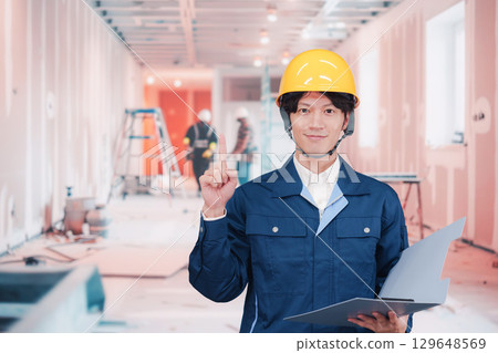 A young male worker working at an interior construction site A young male worker working at an interior construction site 129648569