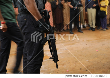 Black Commando hand with gun Black Commando hand with gun 129648662