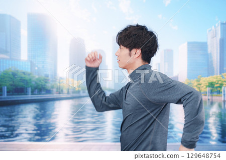 A young man running in the city at lunchtime A young man running in the city at lunchtime 129648754