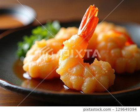 Delicious Golden Fried Tempura Shrimp Appetizer on a Black Plate Cuisine 129649394