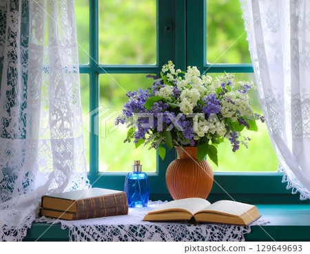 Flowers and books in a vase on a windowsill Flowers and books in a vase on a windowsill 129649693