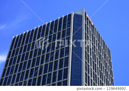 A high-rise building shining against a beautiful blue sky with clouds. July Setagaya 1378 Rakuten Headquarters 129649892