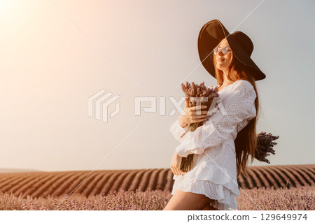 Young Woman in White Dress Posing in Lavender Field 129649974