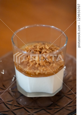 Panna Cotta in a glass cup, on the table in the restaurant Panna Cotta in a glass cup, on the table in the restaurant 129650707