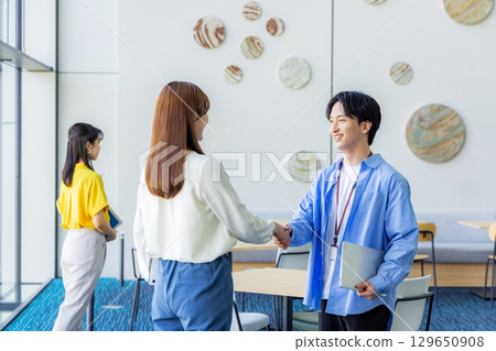 Business men and women shaking hands during a meeting Business men and women shaking hands during a meeting 129650908