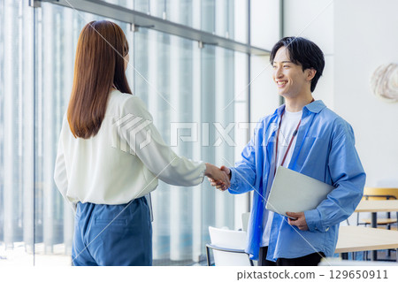 Business men and women shaking hands during a meeting 129650911