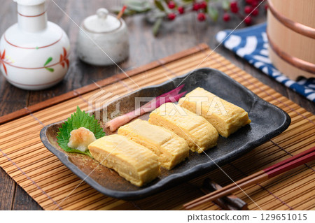 Freshly made, hot rolled omelet in dashi broth. A classic Japanese dish. A perfect table setting for home cooking or izakaya menu. 129651015