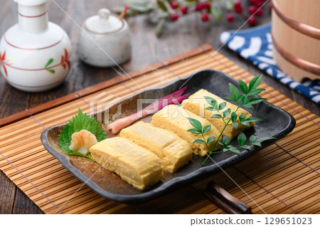 新鮮出爐的熱騰騰的日式煎蛋捲,淋上日式高湯,堪稱經典日式料理。無論是在家烹飪還是在居酒屋享用,都是完美的餐桌擺設。 新鮮出爐的熱騰騰的日式煎蛋捲,淋上日式高湯,堪稱經典日式料理。無論是在家烹飪還是在居酒屋享用,都是完美的餐桌擺設。 129651023