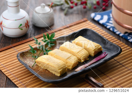 新鮮出爐的熱騰騰的日式煎蛋捲，淋上日式高湯，堪稱經典日式料理。無論是在家烹飪還是在居酒屋享用，都是完美的餐桌擺設。 129651024