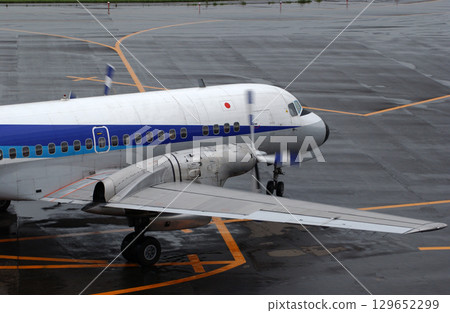 A propeller plane arriving at a rainy airport 129652299