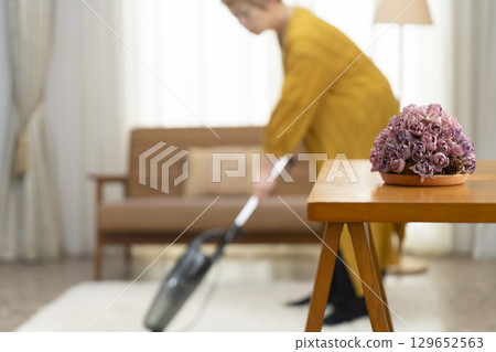 高級婦女在客廳吸塵 129652563