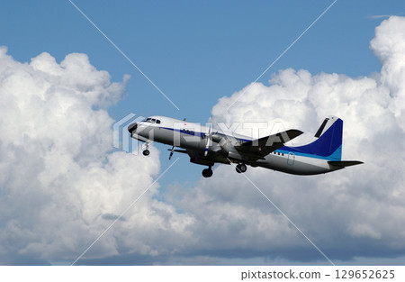 A propeller plane taking off against the backdrop of a blue sky A propeller plane taking off against the backdrop of a blue sky 129652625