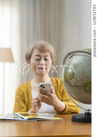 Senior woman looking forward to planning a trip 129652703
