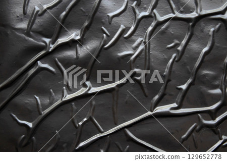 black crumpled and creased plastic poster texture background 129652778