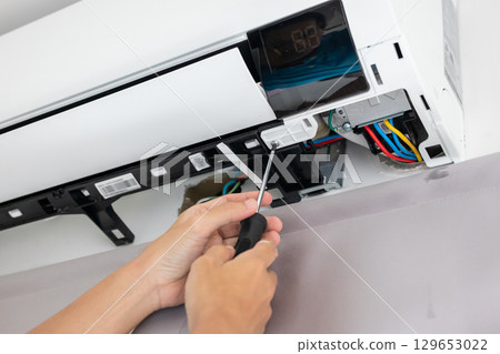 Electrician man repair and maintenance air conditioner 129653022